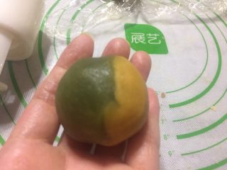 6、双色桃山皮月饼,右手虎口往上推桃山皮，把内馅包住。