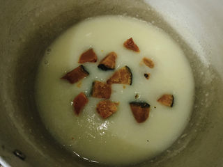 11、玉米南瓜粥,米汤逐渐浓稠,加入南瓜块。继续煮一会儿。