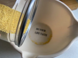 2、苹果小米粥,小米倒入小盆中。