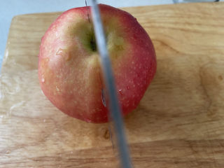 9、苹果小米粥,把苹果切一半。