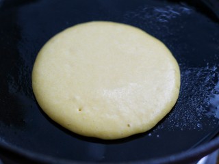 11、牛奶鸡蛋玉米松饼,舀一勺面糊垂直倒入锅中,待表面出现小气孔时翻面
