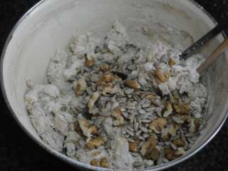 4、圣诞史多伦,然后将面团里的面粉材料和肉桂粉倒入容器中，再倒入辅料里除了水果干和杏仁片以外的其他食材。