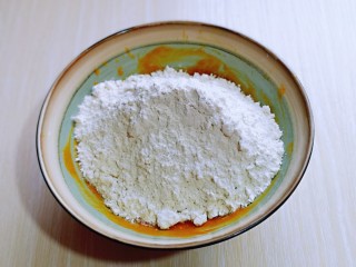 3、南瓜蒸糕,将做好的南瓜泥与面粉放入器具中。