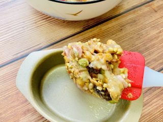 6、麦片酸奶水果杯,把拌好的麦片泥放入模具中，用刮刀轻轻按压成碗型。