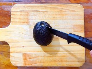 1、吃豆腐+健康饮食之好吃到飞起的牛油果拌豆腐,用锋利的水果刀，如图所示，在牛油果中间绕着划一圈，尽量划得深一点！