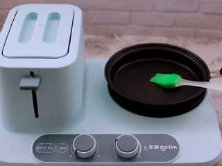 11、好吃到爆的酸奶豆沙酥饼,启动东菱早餐机，锅里用刷子蘸少许食用油均匀涂抹一下后。