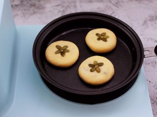 12、好吃到爆的酸奶豆沙酥饼,把做好的面饼放到锅里。