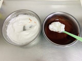 7、红丝绒蛋糕卷,取三分之一的蛋白与蛋黄糊切拌均匀。