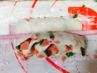 15、葱花火腿卷,取其中一个面团,用筷子在中间轻压,面团两边翘起