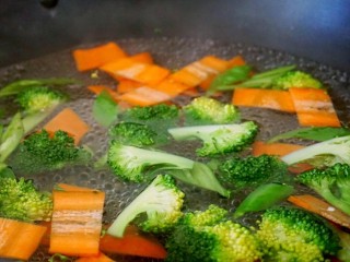 3、西兰花玉米鸡肉糕,锅中加水烧开，把西蓝花和胡萝卜焯水1分钟