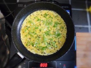 6、青椒虾皮鸡蛋卷,待蛋液煎成型后,撒上葱花和青椒。