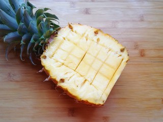 1、菠萝炒饭,先来处理菠萝,将菠萝从叶子下面的三分之一处切开,少的一半去皮只取菠萝果肉,带叶子的一半用水果刀划十字,用勺子挖出菠萝果肉。