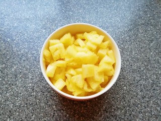 3、菠萝炒饭,取一个大一点容器,放一点点盐加入纯净水,将菠萝果肉在淡盐水里面泡5分钟左右取出,一半的菠萝果肉切成小块炒饭用,另一半可以直接吃了。