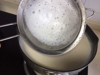 5、自制爽滑豆花,煮的过程可以用面筛把上面的浮沫撇去。