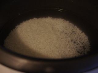 1、电饭锅芥菜肉粥,珍珠米用水浸泡一个晚上。第二天淘洗好米,放入电饭锅,加入足量的水。盖上锅盖,插电源,按煮饭或者煲粥功能键。