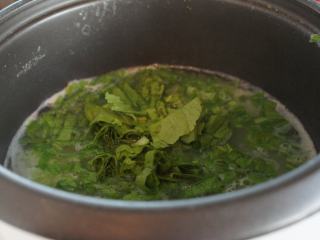 4、电饭锅芥菜肉粥,粥煮好了,加入芥菜。搅拌均匀,大致把芥菜煮软