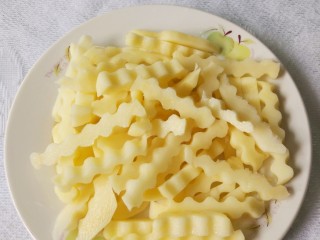 5、孜然土豆,把厚片用工具切成波浪形条状。