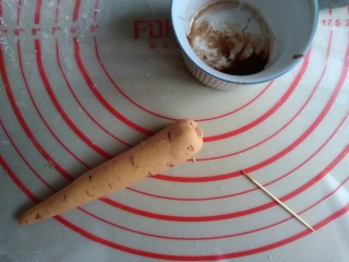 7、象形胡萝卜馒头,可可粉和一丁点水拌一下，用牙签沾点可可液，在胡萝卜身上划出数道纹路。