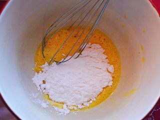 2、香酥芝麻蛋卷,倒入细砂糖和盐，用蛋抽搅打至砂糖完全溶解