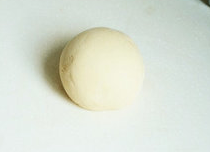 6、糖三角,发酵好的面团取出后在案板上再加入面粉揉搓，揉至面团切开后没有气孔。