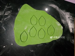 12、花样馒头—寿桃馒头,做成绿色面团后擀薄，用模具压出六个叶子。没有模具可以直接用刀划出一头宽一头尖的叶子形状。