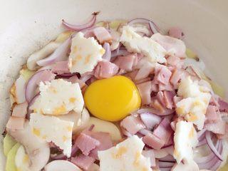 8、培根蘑菇薯片薄饼,在中间打上鸡蛋，并铺上芝士碎