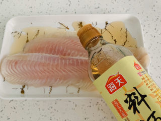 4、清蒸巴沙鱼柳,在姜丝上面放上鱼柳，加入料酒。