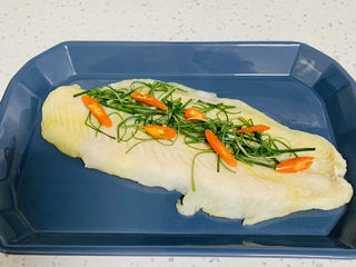 9、清蒸巴沙鱼柳,蒸好的鱼肉取出装入盘中放入葱丝、小米辣。