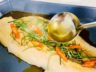 11、清蒸巴沙鱼柳,在浇洒热油淋在葱丝鱼肉上。