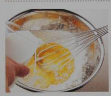 1、双色可丽饼,事先混合好牛奶、鸡蛋和砂糖,在面粉中间挖一个坑,倒入混合溶液。用打蛋器从中央开始,慢慢向外旋转着搅拌,让面粉一点点溶解,搅拌至材料柔滑,没有大颗粒。