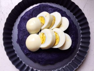 6、焗烤紫土豆鸡蛋,然后找一个能进烤箱的容器，先把土豆泥铺底下，上面摆放鸡蛋片。