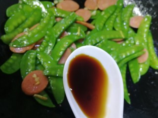 13、荷兰豆炒香肠,放入半汤匙生抽，炒匀即可。