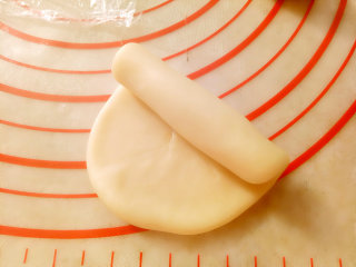 6、中式点心+蛋黄酥,把包好的酥皮依次用擀面杖擀成牛舌形（长度10CM左右）卷起来,盖保鲜膜松弛10分钟。