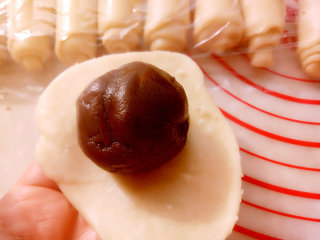 10、中式点心+蛋黄酥,用擀面杖擀成圆形放入之前准备好的豆沙蛋黄馅包好。