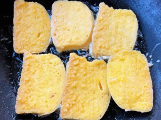 6、香煎馒头片,锅中倒入油加热再依次放入吸饱蛋液的馒头片中火开始煎制