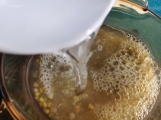 7、绿豆小米粥,第二次再加入一碗凉水,继续煮约二三分钟。