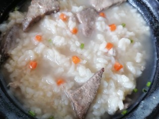 16、猪肝瘦肉粥,放入胡萝卜颗粒炖至粥浓稠即可关火，然后撒上葱花