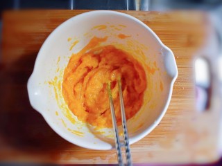 7、紫薯南瓜糯米糕,用筷子或勺子将蒸熟的南瓜搅成泥。