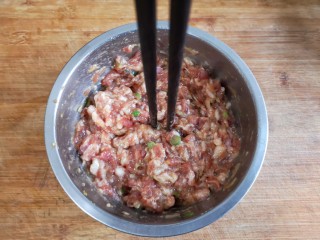 8、烫面海菜大包,顺一个方向搅拌均匀，搅上劲儿，筷子能立在肉馅中不倒就是搅上劲儿了。