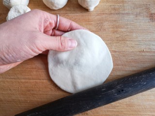 14、烫面海菜大包,将面剂子按扁擀成中间略厚边缘薄的包子皮。