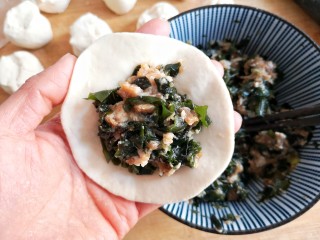 15、烫面海菜大包,在包子皮中间填上适量的馅料。
