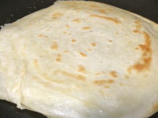 15、早餐美味鸡蛋灌饼,一面定型后再翻面继续慢煎，随着加热面饼中间就会慢慢的鼓起包