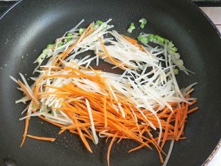 6、土豆丝火腿鸡蛋饼,倒入土豆丝。胡萝卜丝炒软。七八成熟。最后倒入火腿丝，翻炒两下盛出待用