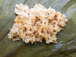 16、荷香糯米鸡,荷叶分成2份,取一份铺上一层糯米饭,铺平