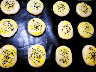 19、简易版老婆饼,此时烤箱180度预热，蛋黄加一小勺水打散，均匀刷好表面，撒黑芝麻，用锋利的小刀或者刀片在表面割三刀，一定要割透，其实割口除了好看，还可以预防烘烤时爆馅！