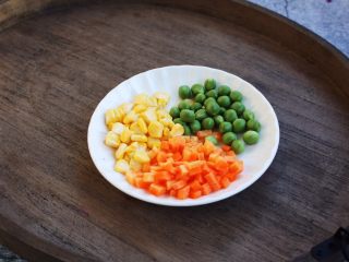 3、芝士焗番茄鲜虾米饭盅,胡萝卜切丁，玉米掰成粒，豌豆洗干净备用。