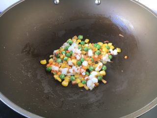 7、芝士焗番茄鲜虾米饭盅,然后放入鲜虾粒，翻炒几下（15秒左右）至鲜虾变粉色。