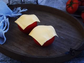 13、芝士焗番茄鲜虾米饭盅,在番茄盅的表面各放上一张芝士片。