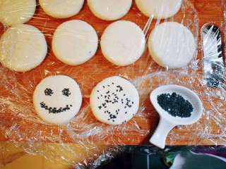 17、紫薯山药糯米饼（微笑饼）,取适量的黑芝麻，撒在饼的表面。可以按照自己的喜好来装饰，我装饰成了笑脸。