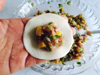 9、芹菜玉米猪肉馅饺子,取一饺子皮放在手上放入适量的馅